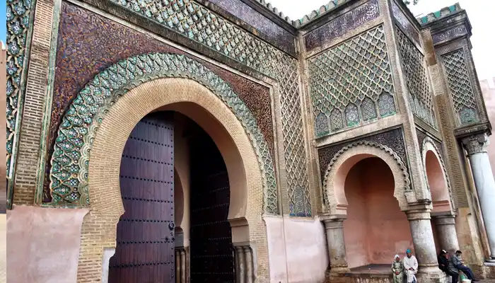 Close-up view of the intricate tilework and grand arches of Bab Mansour, an iconic architectural landmark in Meknes, Morocco.