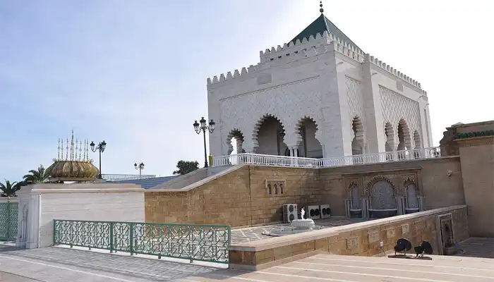 Mausoleum of Mohammed V in Rabat, Morocco, a stunning white marble structure with intricate tilework and a green pyramid-shaped roof.