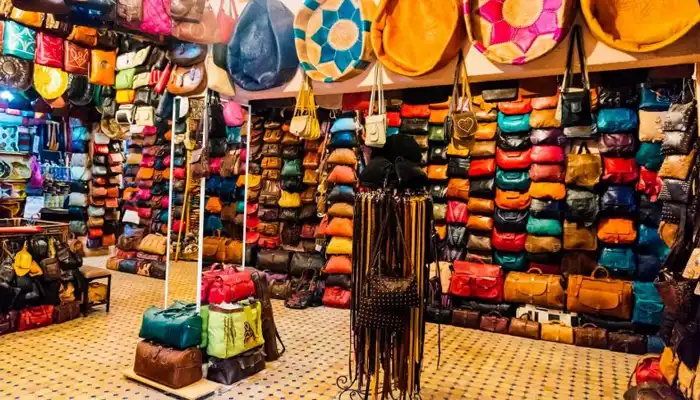 Vibrant leather goods displayed in a Fes medina shop, featuring handcrafted bags, belts, and Moroccan slippers dyed in rich, natural colors.