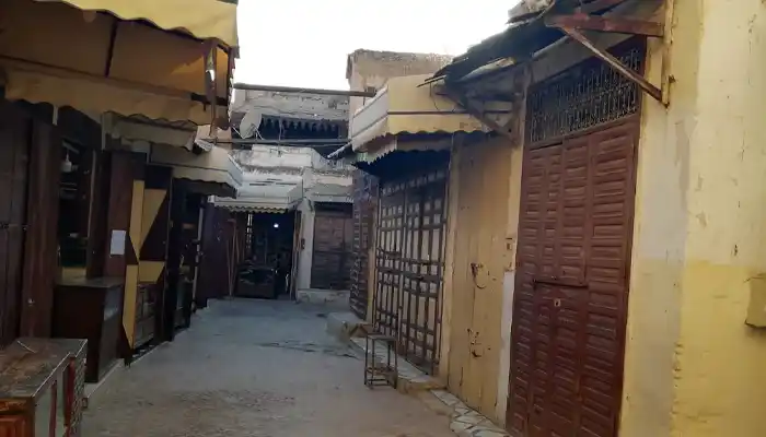 Souk El Herir in Meknes, showcasing luxurious silk fabrics, colorful textiles, and traditional Moroccan garments, highlighting the souk’s refined craftsmanship and elegance.