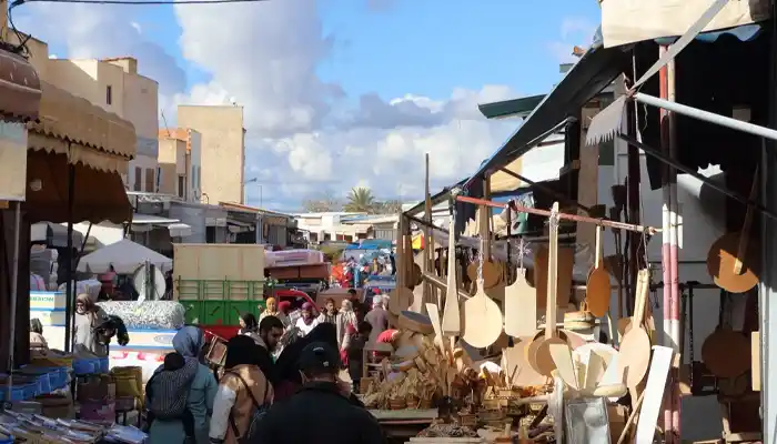 Artisanal stalls at Souk Nejjarine in Meknes displaying intricately carved wooden crafts, furniture, and traditional Moroccan decor, showcasing the souk’s rich woodworking heritage.