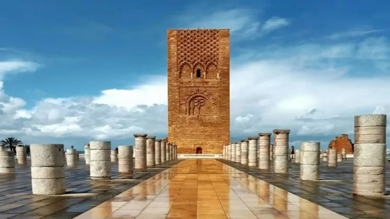 Side view of Hassan Tower in Rabat, Morocco, showcasing its intricate red sandstone design and Almohad architecture.