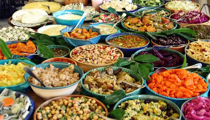 Traditional Moroccan dishes being prepared in a Meknes kitchen, featuring tagine, fresh ingredients, and vibrant spices that showcase the region's rich culinary heritage.