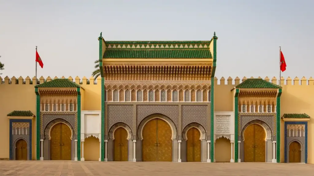 Golden gates of the Royal Palace in Fes, showcasing intricate Moroccan craftsmanship and geometric designs.